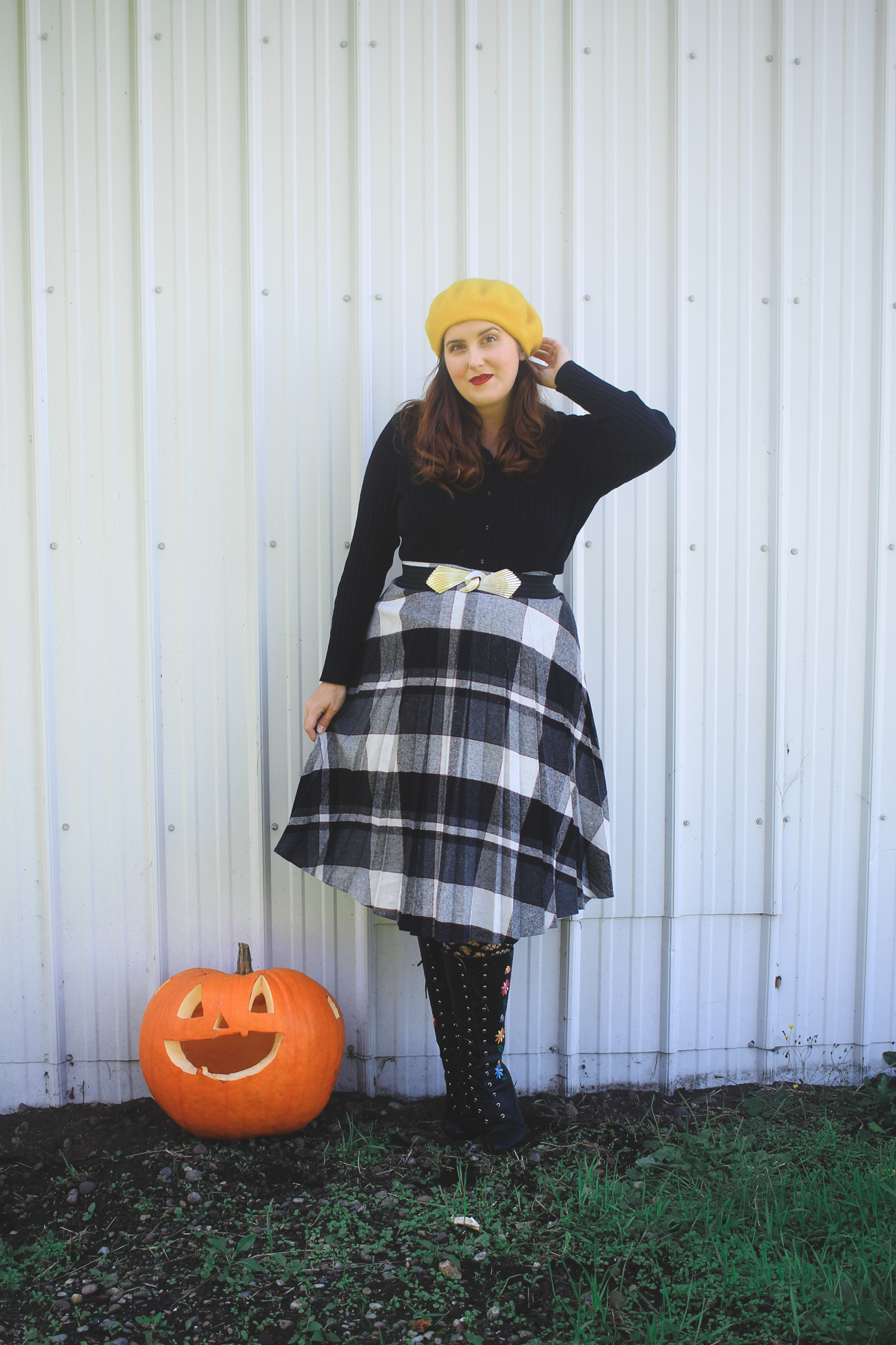 woman wearing a yellow beret and a plaid skirt